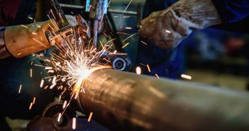 worker welding a steel pipe