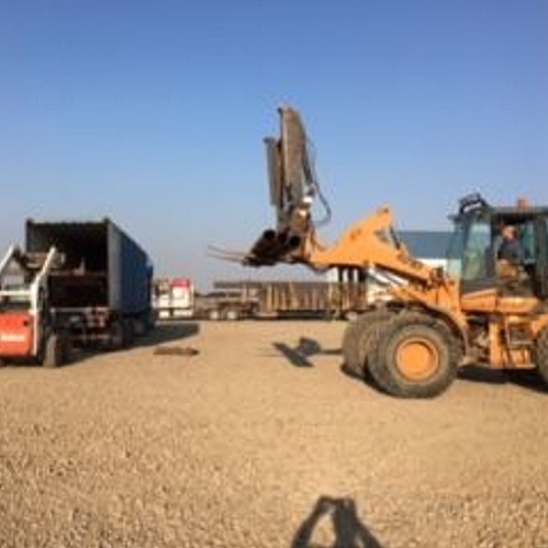 Image of excavator and trailer on an open field