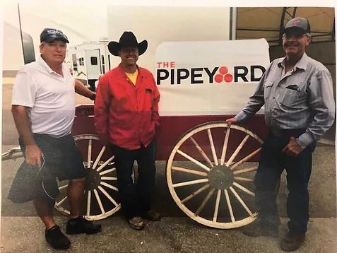 Image of three men posing with a chuck wagon