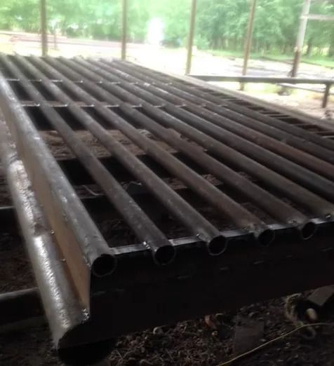 Image of a metal cattle guard laying on the ground